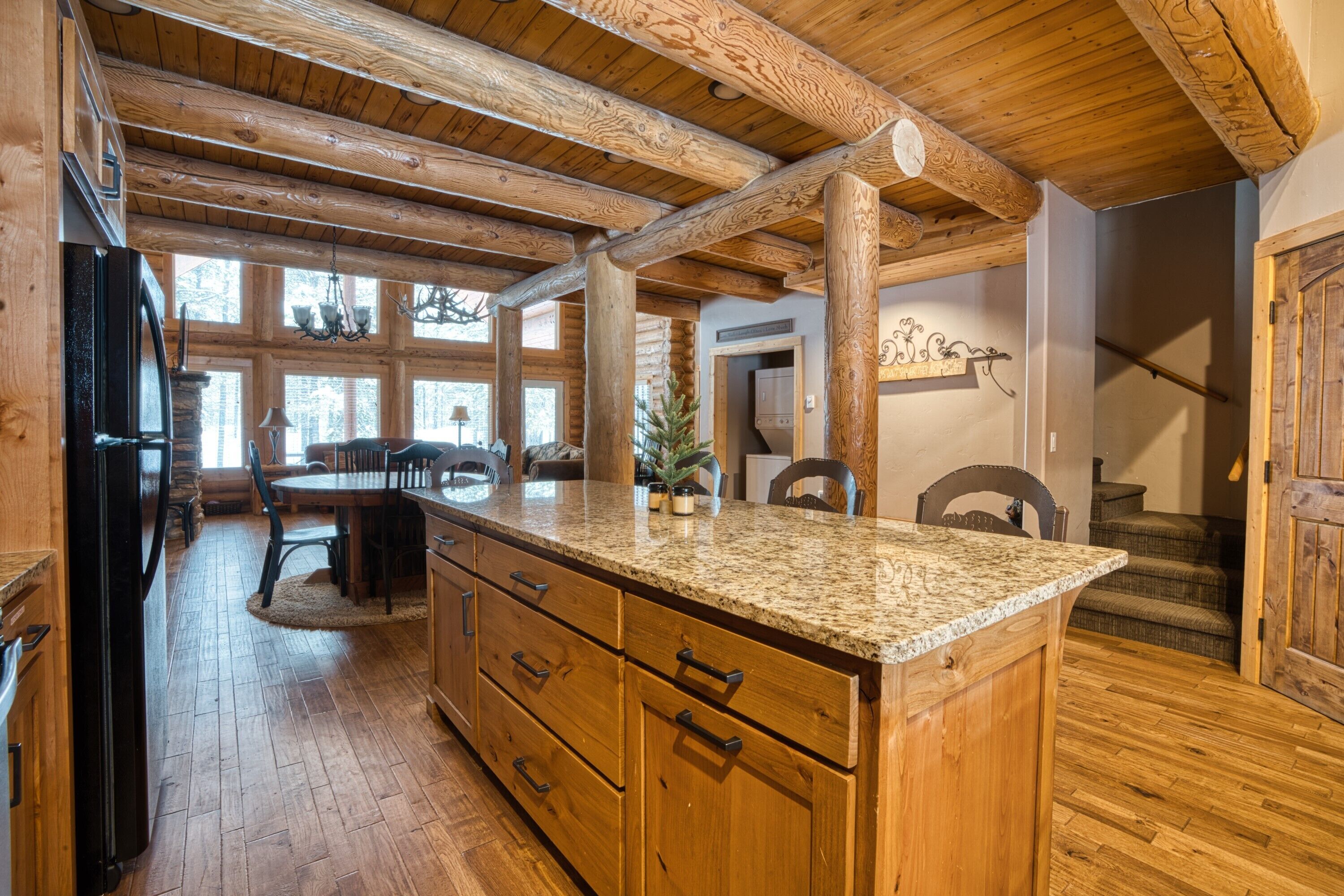 Un intérieur en bois avec un îlot de cuisine, des poutres apparentes et un coin repas.