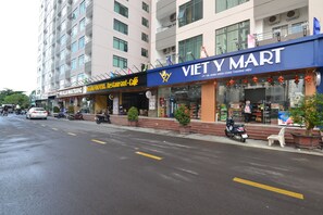 A multi-story building with a storefront labeled "VIET Y MART" and another labeled "PARALIA NHATRAING WARD HOTEL RESTAURANT-CAFE". - The Crystal Apartment (Bac Nha Trang)