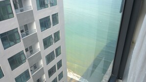 Ein Hochhaus mit mehreren Balkonen mit Blick auf ruhiges Wasser.