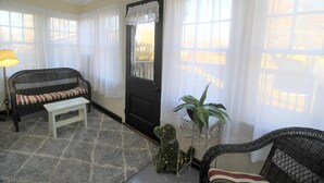 A cozy living room with a sofa, a small table, and a potted plant. - Tastefully restored historic home in quaint town, 20 minute drive to Columbia MO (Centralia)
