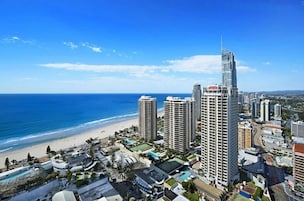 Un paisaje urbano costero con rascacielos, una playa y un cielo azul despejado.