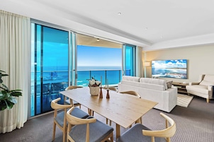 Una habitación amplia con una gran mesa de comedor, dos sofás y un televisor.
