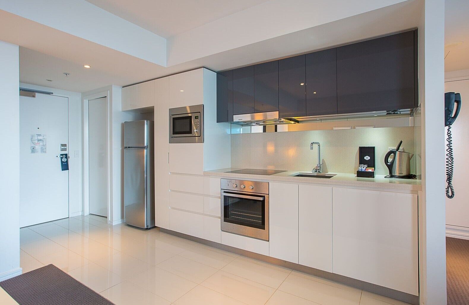 A modern kitchen with stainless steel appliances, a built-in microwave, and a coffee machine.