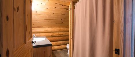 A wooden cabin bathroom with a wooden sink and toilet.