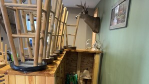 Una habitación con estructura de madera, una cabeza de ciervo montada y un cuadro en la pared.