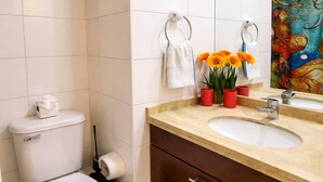 Une salle de bain avec des toilettes, un lavabo, un miroir et un tapis bleu.
