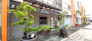 A Z Hotel with a modern facade, outdoor seating area, and potted plants.