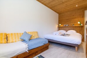 Une chambre à coucher avec un lit, un canapé et un plafond en bois.