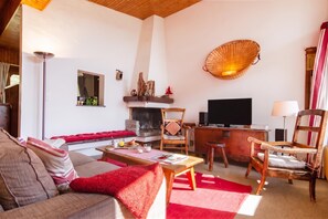 A cozy living room with a sofa, a coffee table, a fireplace, and a television. - Chalet Dava La Via ski in/ski out, Le Tour (Argentière), France (Le Tour (Argentière))