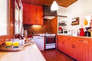 Une cuisine de taille réduite, dotée de meubles en bois, d’un four encastré et d’un four à micro-ondes.
