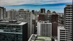 Un paisaje urbano con edificios altos, incluyendo un moderno edificio de vidrio y varias construcciones marrones y blancas.
