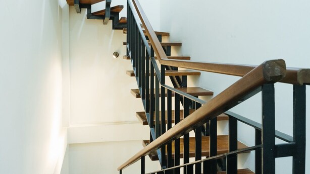 A wooden staircase with black railings and a handrail. - The Eighty8 Hanoi Hostel (Hanoi)