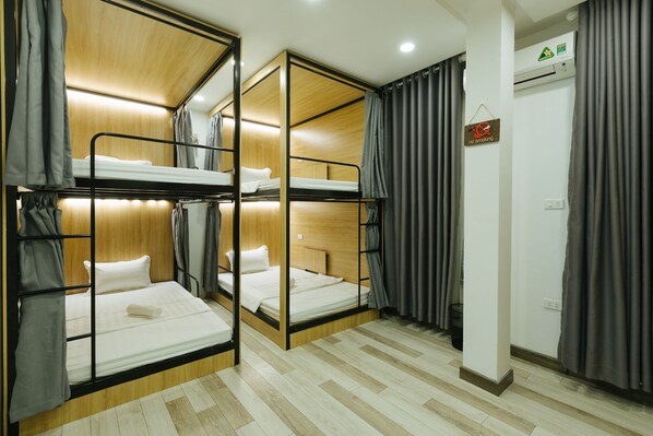 A room with bunk beds, a no smoking sign, and an air conditioning unit.