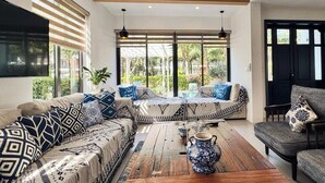 A living room with a sofa set, a coffee table, and a decorative vase. - M Villas Phu Quoc (Phu Quoc)