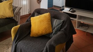 A living room with a sofa, television, and a dining area with a table and chairs. - GITE 7/8 P. LE NAPOLEON, Not suitable for PRMs (Saint-Leu-la-Forêt)