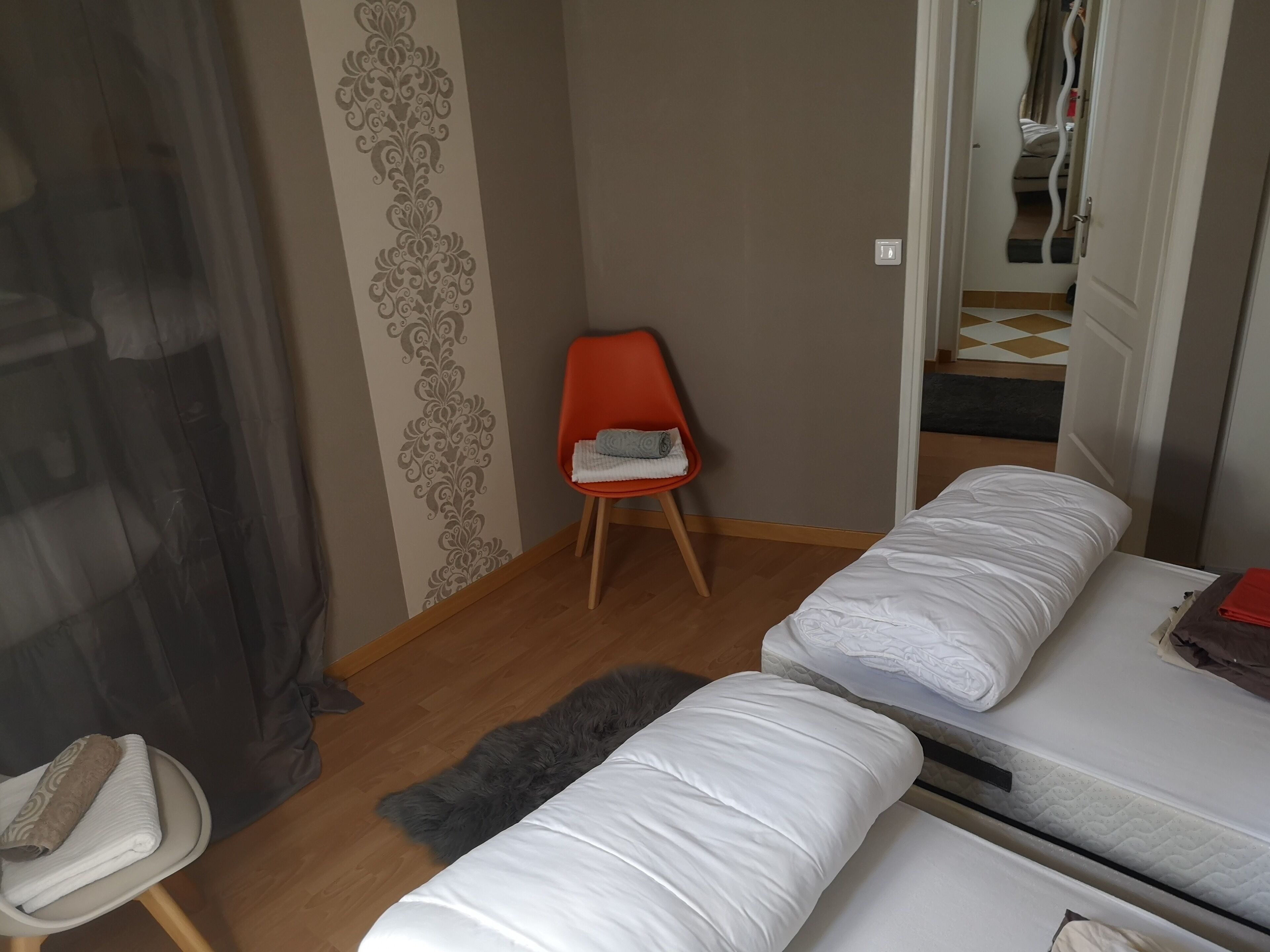 A small, cozy room with a bed, a chair, and a small table.
