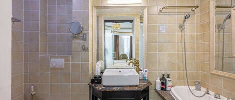 A bathroom with a white sink, a black vanity, a bathtub, and a shower area.