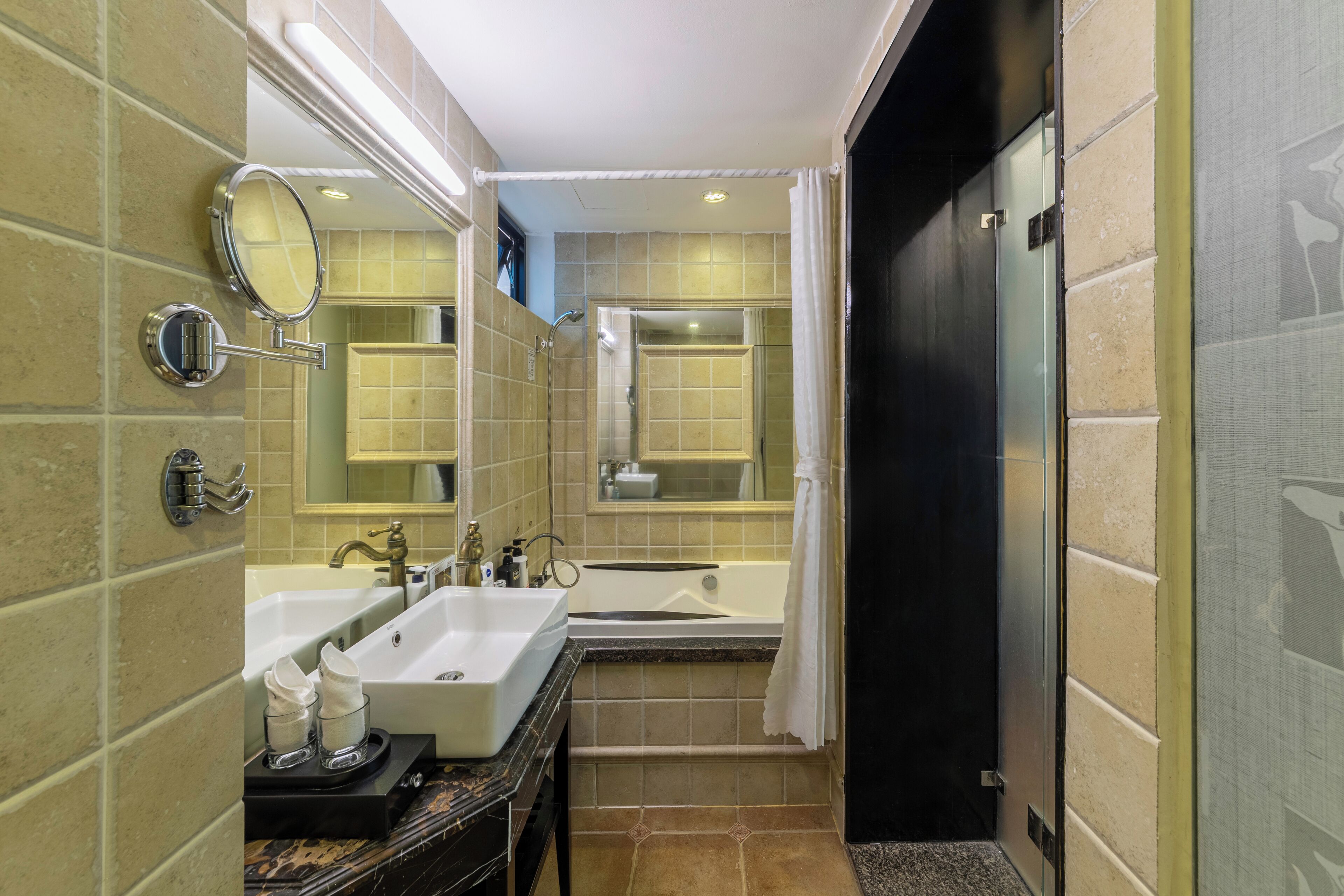 Un baño moderno con dos lavamanos, una bañera y una ducha.