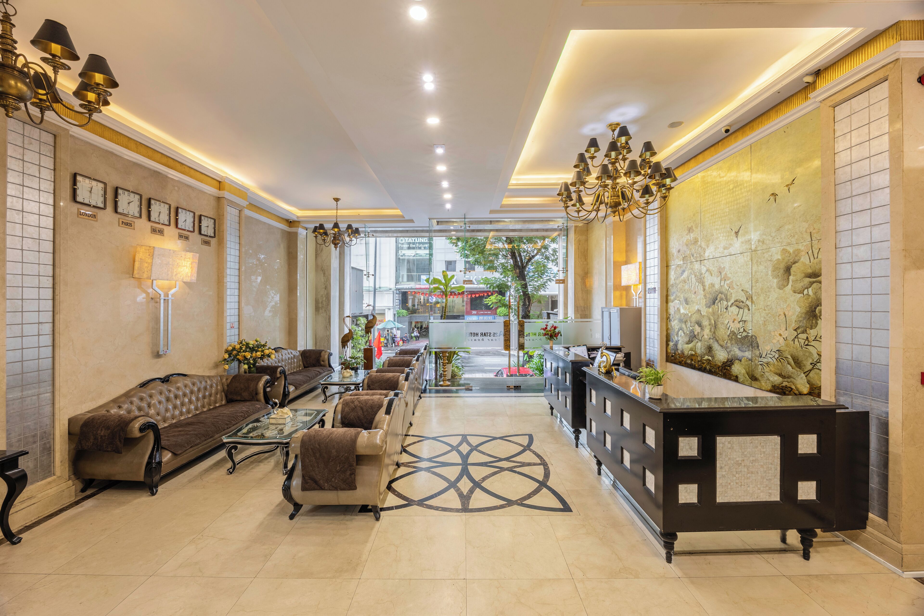 A spacious lobby with a reception desk, seating area, and a large decorative wall.