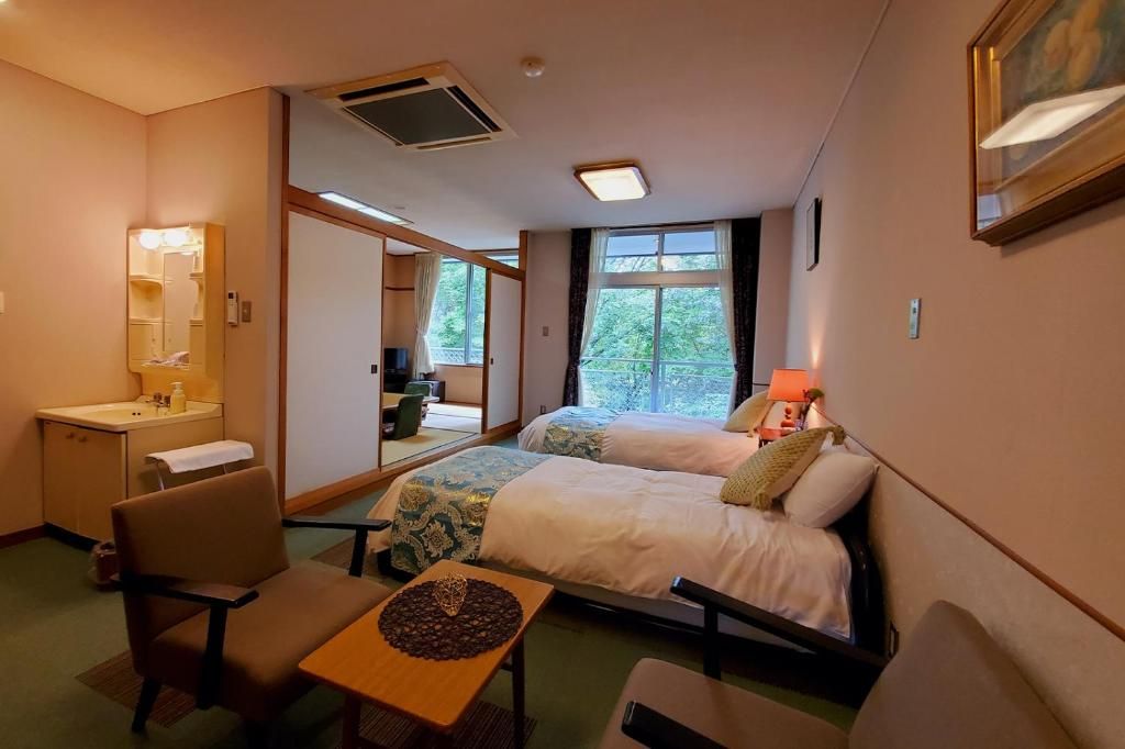 Una habitación de hotel con una cama, un escritorio, una silla, una mesita y una ventana.