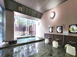 Un baño con una bañera grande, zona de ducha e lavamanos con espejos.