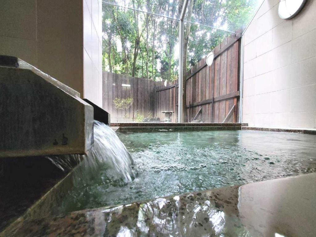 Un jacuzzi con valla de madera y un reloj en la pared.