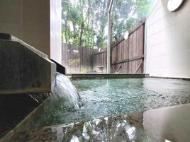 Un jacuzzi con valla de madera y un reloj en la pared.