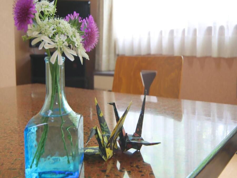 Un florero de vidrio con flores sobre una mesa.