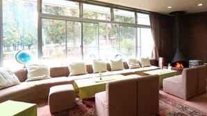 Una habitación acogedora con sofá, sillones, una mesa y chimenea.