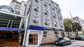 Ein Hotel mit moderner Fassade, mehreren Klimaanlagen und einem Zugang zur Tiefgarage.