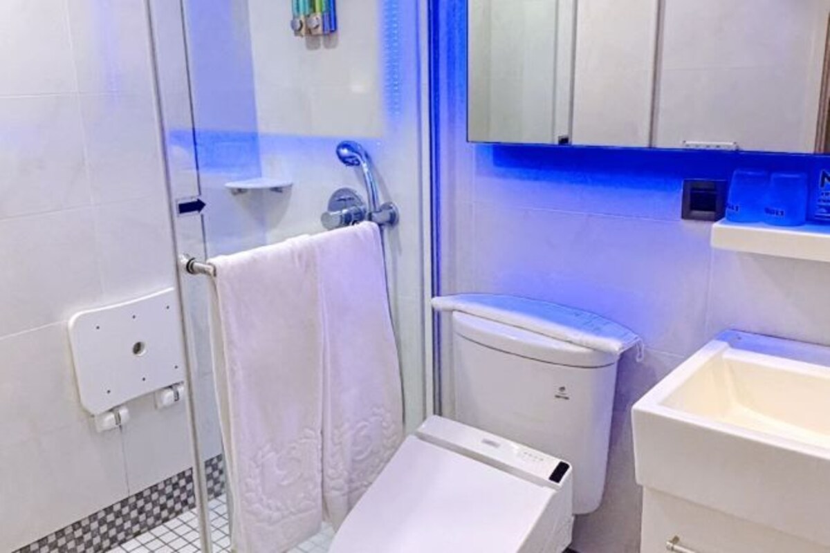 Une salle de bain moderne équipée d’une douche, de toilettes et d’un lavabo.