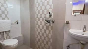 A bathroom with a toilet, sink, and patterned wall tiles.