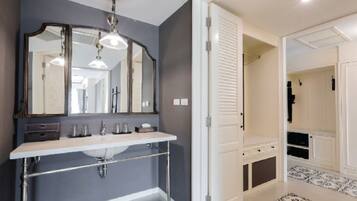 A bathroom with a white vanity, a large mirror, and a hanging light fixture.