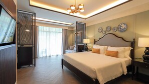 Une chambre d’hôtel avec un grand lit, des tables de chevet, un luminaire au plafond et des assiettes décoratives accrochées au mur.