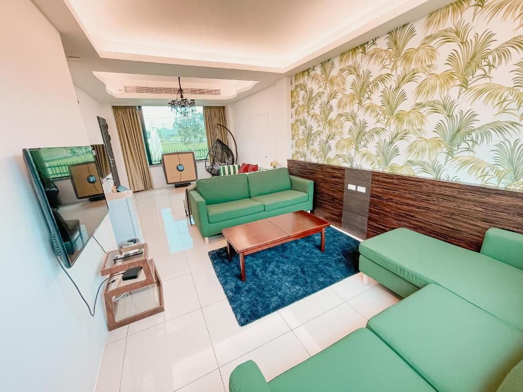 A modern living room with a green sofa set, a wooden coffee table, and a television.