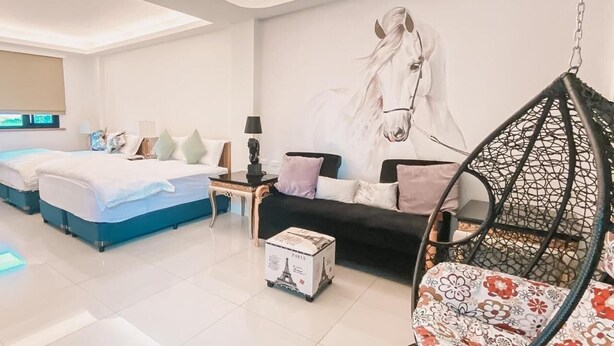 A modern hotel room with a large bed, a sofa, a hanging chair, and a wall mural. - Marburg Hall (Sanxing)