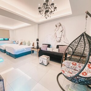 Une chambre d’hôtel moderne dotée d’un grand lit, d’un canapé, d’un fauteuil suspendu et d’une fresque murale.