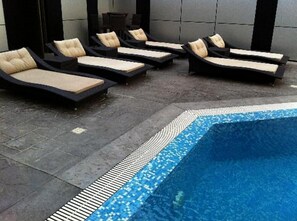 A poolside area with lounge chairs and a tiled edge. - Adsuit Hotel Calabar (Calabar)