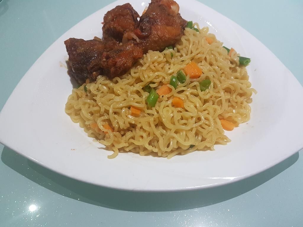 Une assiette de nouilles sautées aux légumes et au poulet, servie dans une assiette blanche.