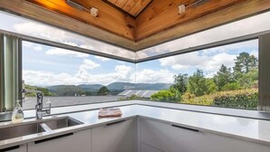 Une cuisine moderne dotée d’une grande fenêtre, d’un évier et d’un plan de travail.