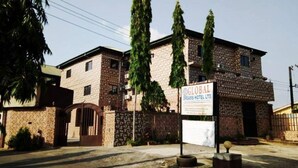 A two-story building with a sign for Global Dreams Hotel Ltd. - Global Dreams Hotel (Calabar)