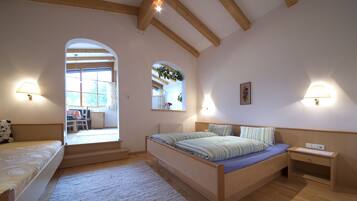 Un dormitorio con una cama, una mesita de noche, una lámpara y una ventana.
