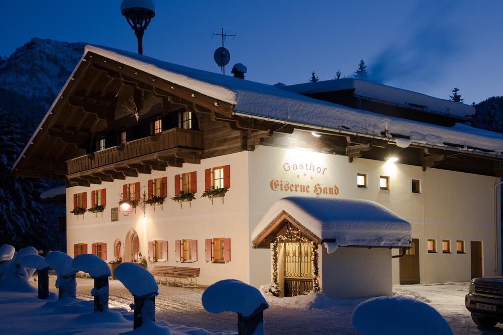 A snow-covered building with a sign reading "Gasthof Givernese Haus."