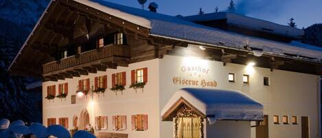 A snow-covered building with a sign reading "Gasthof Givernese Haus."