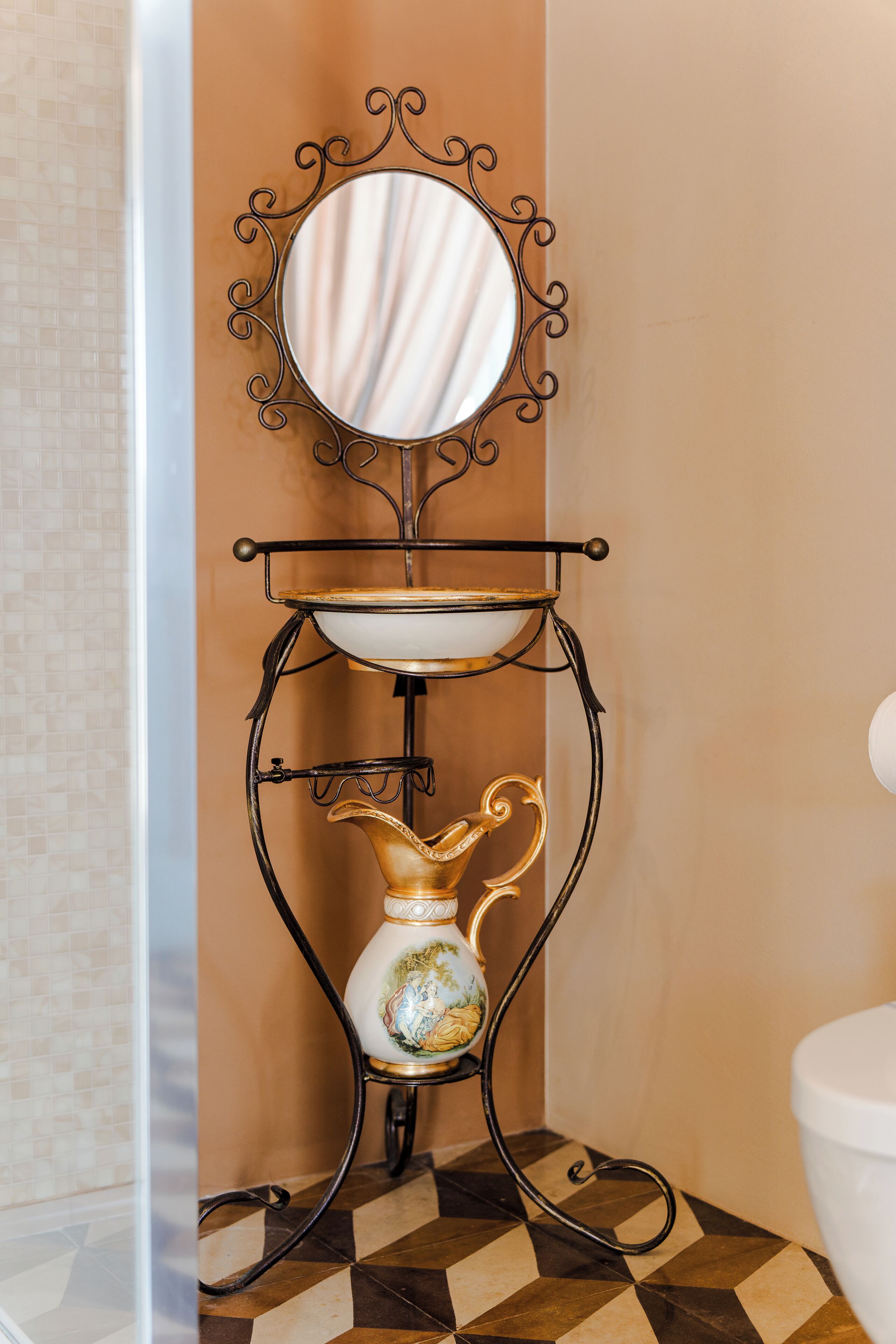 A bathroom with a tiled floor, a sink with a decorative vase, and a wall-mounted mirror.