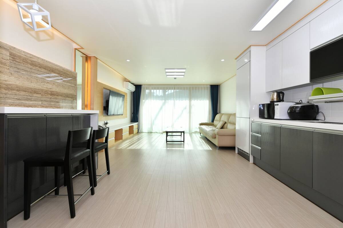 Una cocina moderna con comedor, sofá y televisor.