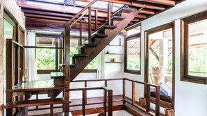 A wooden staircase with a railing, leading to a higher floor. - Greenhouse Siargao (General Luna)