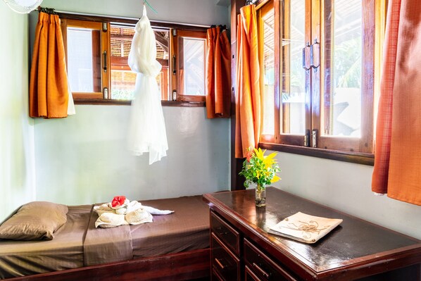 A room with a bed, a wooden desk, and a window with curtains. - Greenhouse Siargao (General Luna)