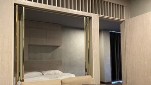 Une chambre moderne avec un canapé, un lit et un grand miroir.