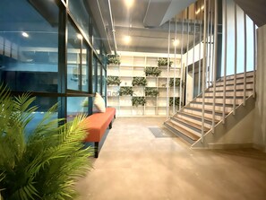 A modern interior with a staircase, a bench, and indoor plants. - 44 Room Rama 3 (Bangkok)